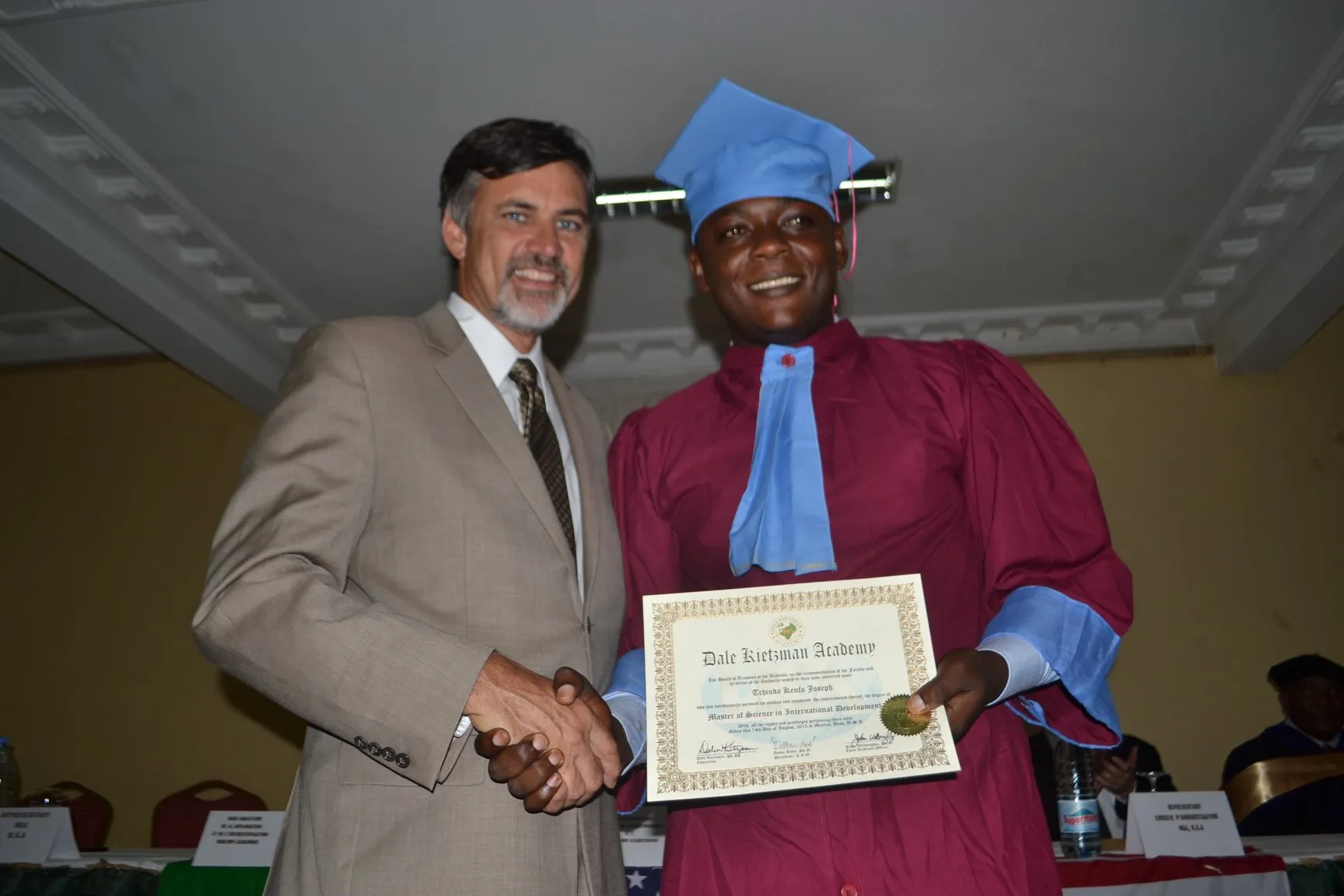 Scholarship-supported graduate receiving certificate.